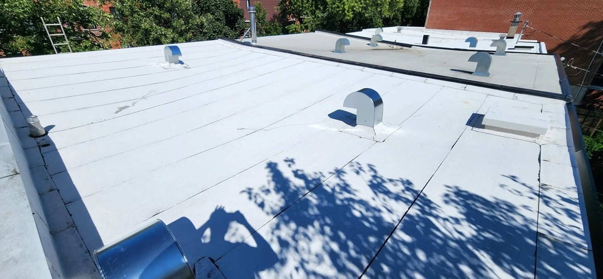 Toit plat avec membrane elastomère blanche.