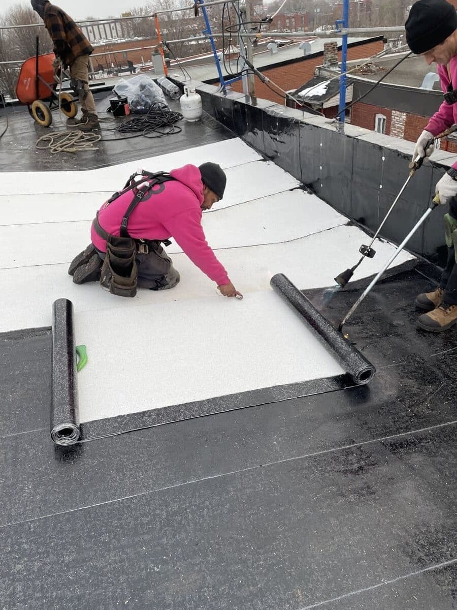 Ouvrier de Toitures JSB qui installe une membrane elastomère.